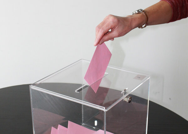 Photo "élections" (main qui dépose une enveloppe dans une urne) | Crédit : Myriam Lakraa